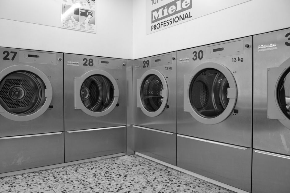 A sleek row of industrial washing machines in a modern laundromat, conveying efficiency and cleanliness.